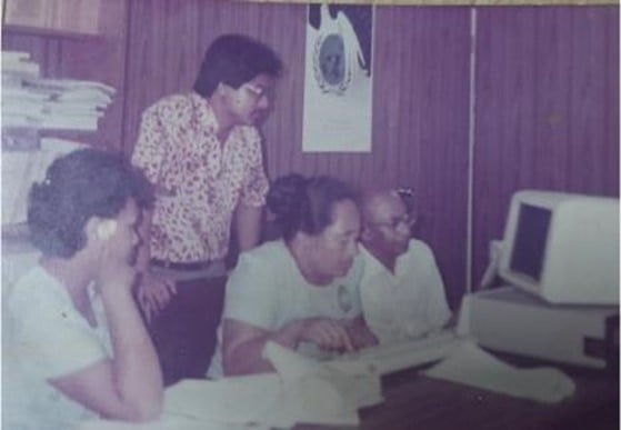 WHO Samoa staff work together in front of a computer