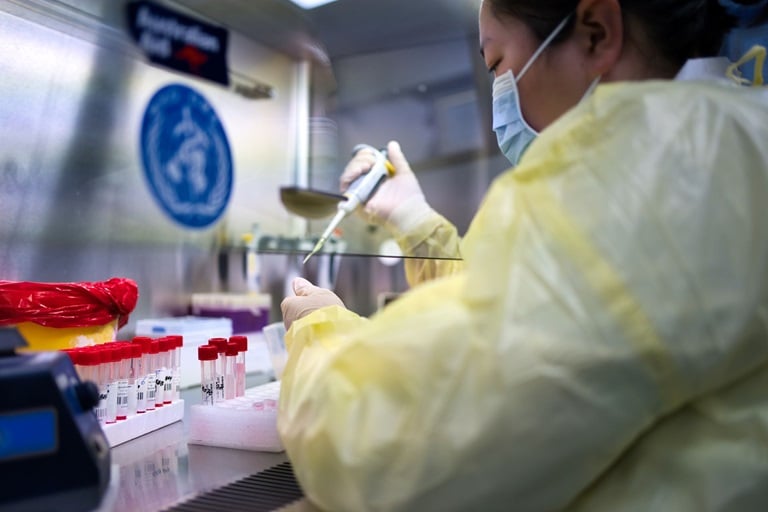 A lab worker with test tubes in a lab in Mongolia wearing a mask and personal protective equipment